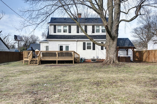 rear view of house featuring a fenced backyard, a gazebo, roof with shingles, a wooden deck, and a chimney