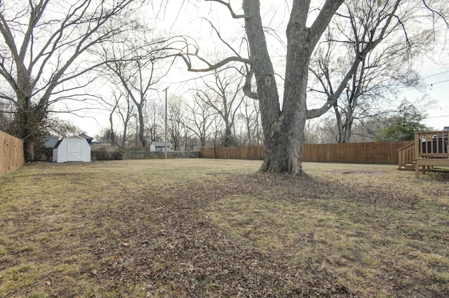 view of yard featuring an outbuilding, a storage unit, and a fenced backyard