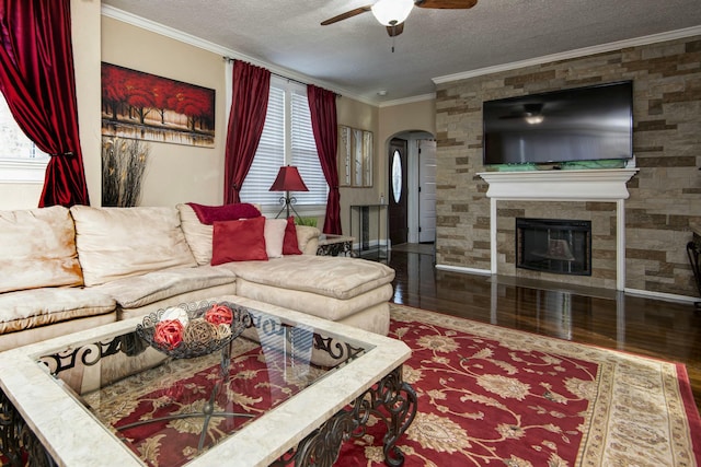 living room with crown molding, ceiling fan, wood finished floors, arched walkways, and a textured ceiling