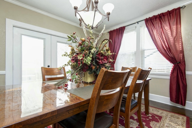 dining area with a wealth of natural light, a notable chandelier, crown molding, and baseboards