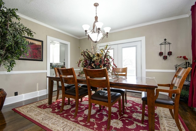 dining room with baseboards, wood finished floors, a chandelier, and ornamental molding