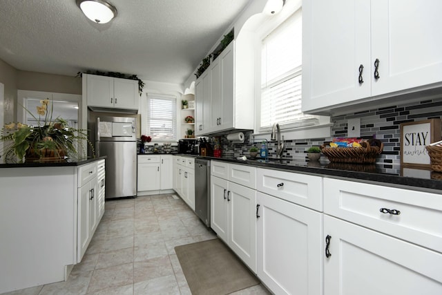 kitchen featuring white cabinets, a wealth of natural light, and stainless steel appliances