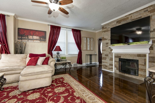 living room with wood finished floors, a ceiling fan, arched walkways, a textured ceiling, and crown molding