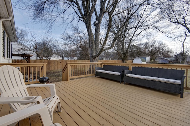 wooden terrace featuring an outbuilding, outdoor lounge area, and a fenced backyard