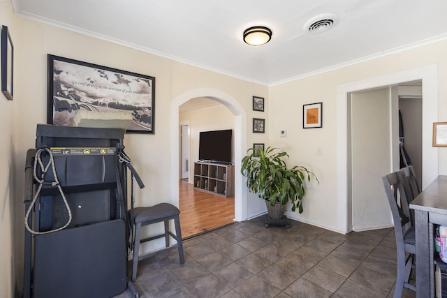 interior space with crown molding, visible vents, and arched walkways