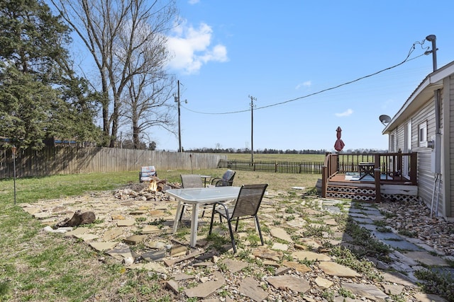 view of yard featuring a wooden deck, a fenced backyard, and outdoor dining space