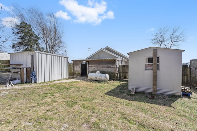 view of yard featuring an outbuilding, fence, and a shed