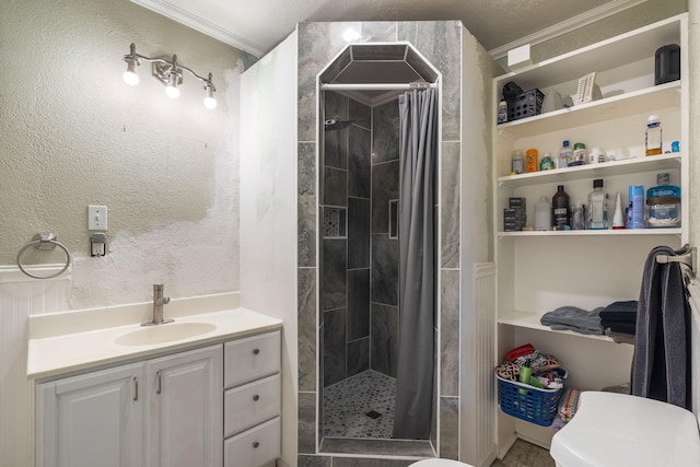 bathroom with vanity, crown molding, a textured wall, and a tile shower