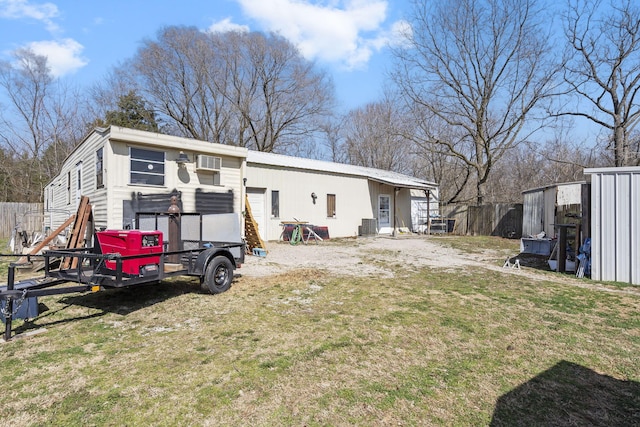 rear view of property featuring a yard and fence