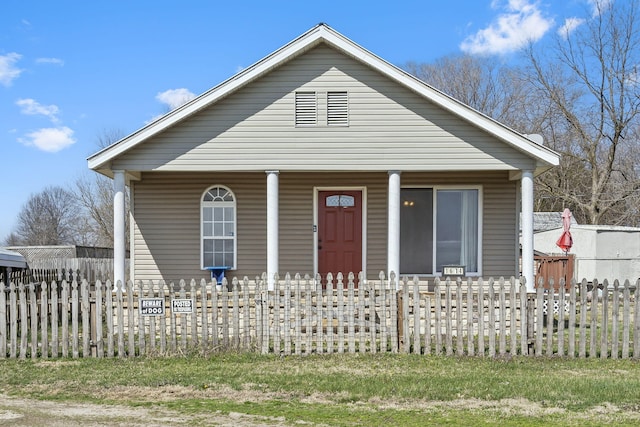 bungalow-style house featuring a porch and a fenced front yard