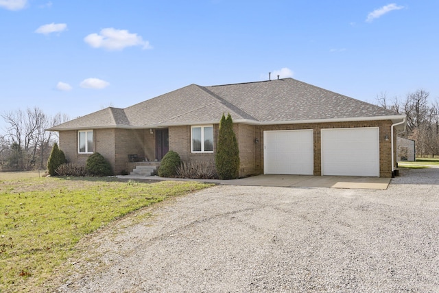 single story home featuring brick siding, an attached garage, gravel driveway, and roof with shingles