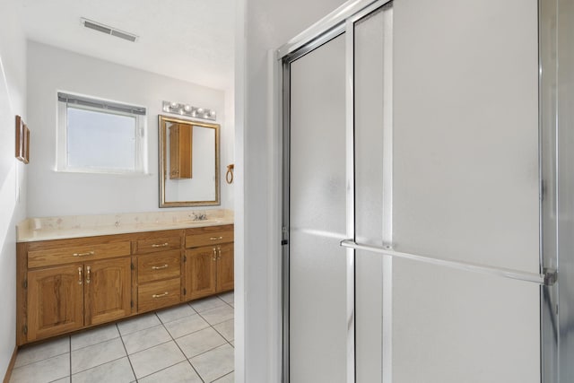 bathroom with tile patterned flooring, visible vents, a stall shower, and vanity