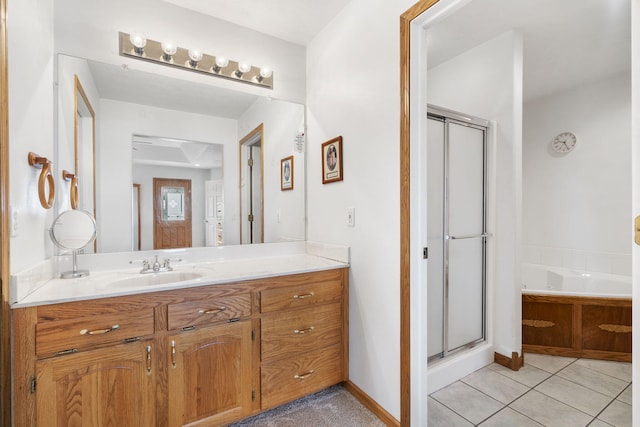 bathroom featuring tile patterned flooring, a shower stall, baseboards, a garden tub, and vanity