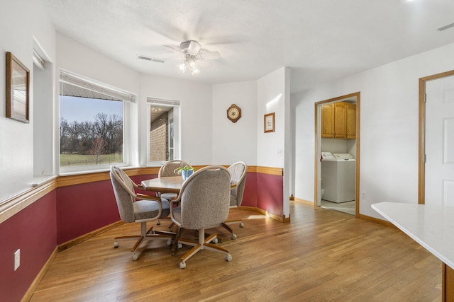 dining space with light wood finished floors, visible vents, a ceiling fan, and baseboards