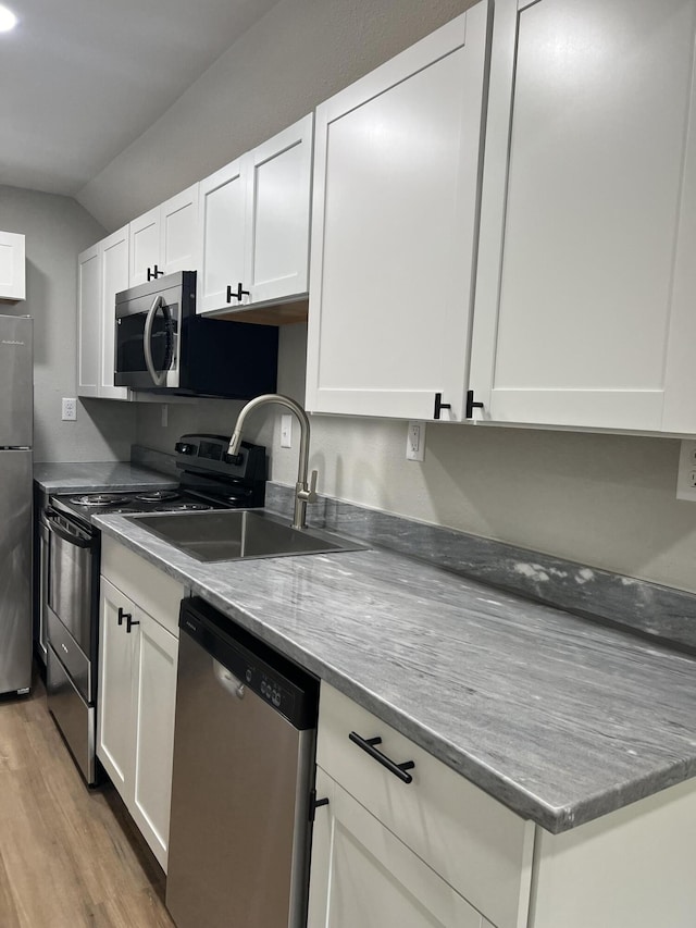 kitchen featuring a sink, light wood-type flooring, appliances with stainless steel finishes, and white cabinets