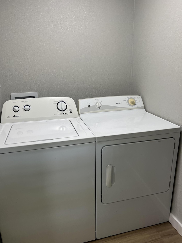 laundry room with separate washer and dryer, wood finished floors, and laundry area