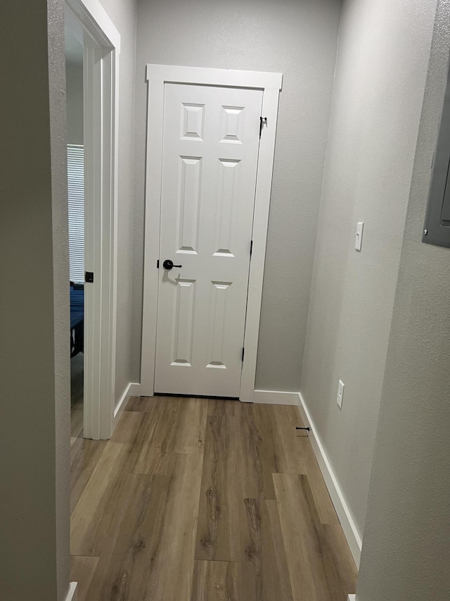 corridor with wood finished floors and baseboards