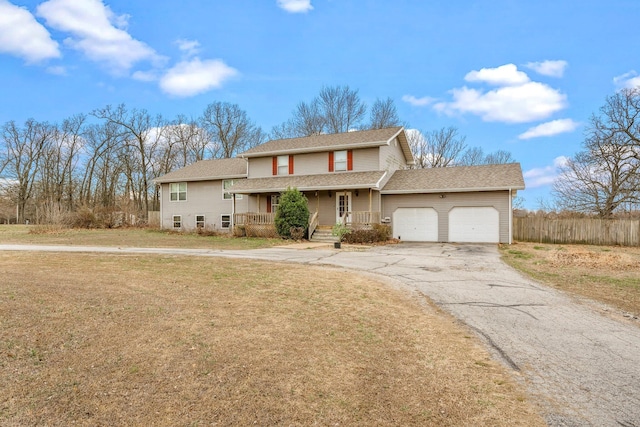 traditional home with driveway, roof with shingles, a porch, a front lawn, and a garage