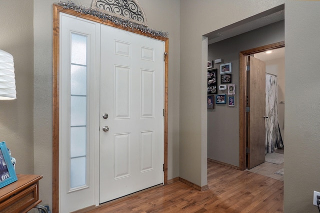 foyer featuring baseboards and wood finished floors