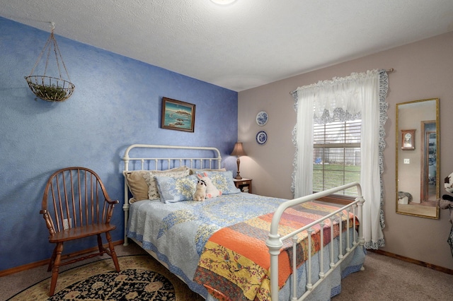 bedroom featuring a textured ceiling, baseboards, and carpet