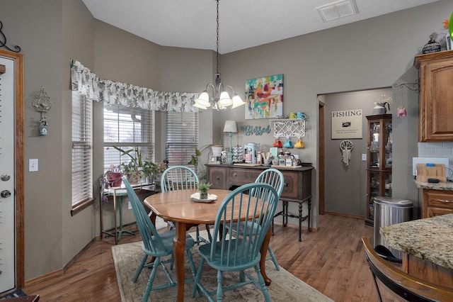 dining area with a notable chandelier, visible vents, and wood finished floors