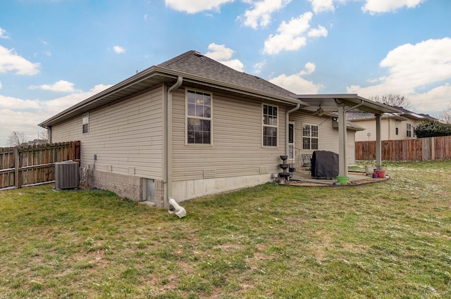 back of property with a patio area, a lawn, central AC unit, and fence