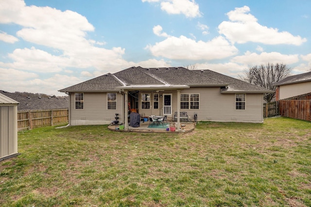 back of property featuring a fenced backyard, a yard, a shingled roof, and a patio