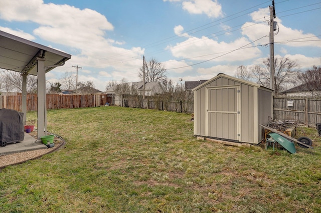 view of yard with a fenced backyard, an outbuilding, and a storage shed