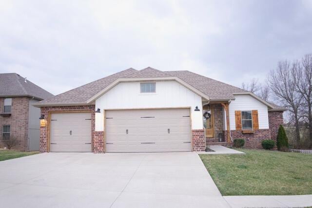 view of front of property with brick siding, a front lawn, roof with shingles, a garage, and driveway