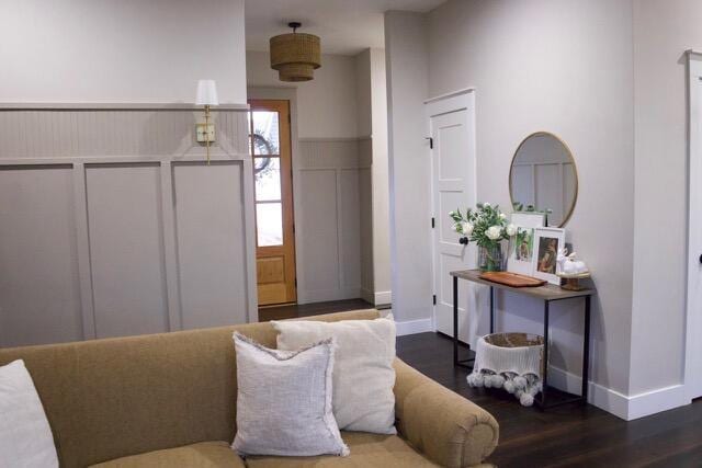 entrance foyer featuring baseboards, wood finished floors, and a decorative wall