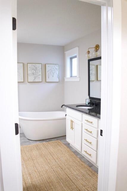 full bath with vanity and a freestanding bath