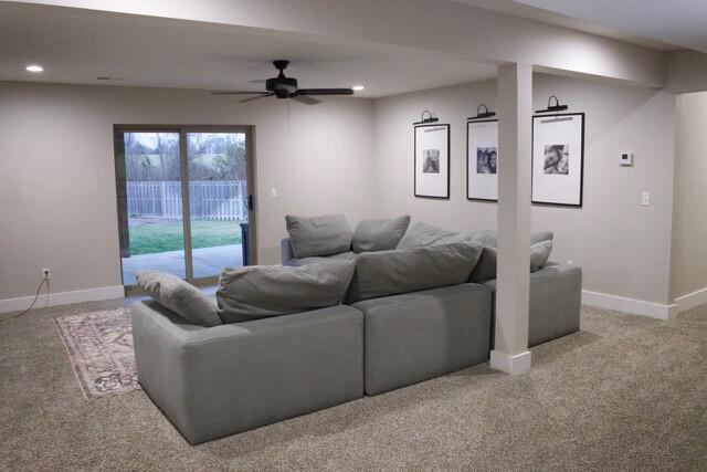 living room with carpet, a ceiling fan, and baseboards