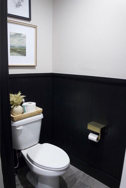 bathroom featuring a wainscoted wall and toilet