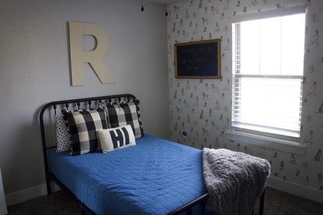 bedroom featuring wallpapered walls and baseboards