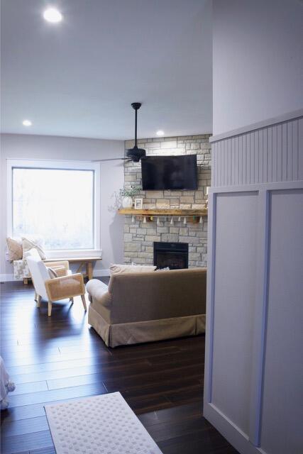 living area with a stone fireplace, recessed lighting, and hardwood / wood-style floors