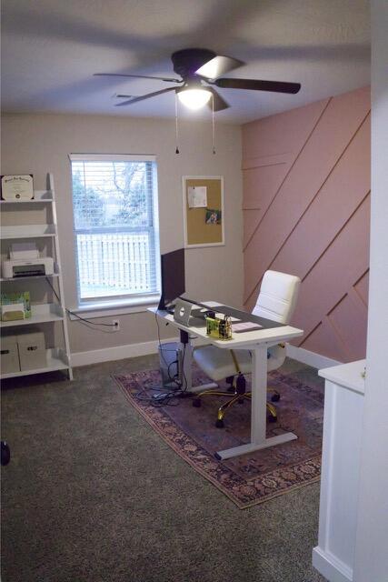 carpeted office space with baseboards and a ceiling fan