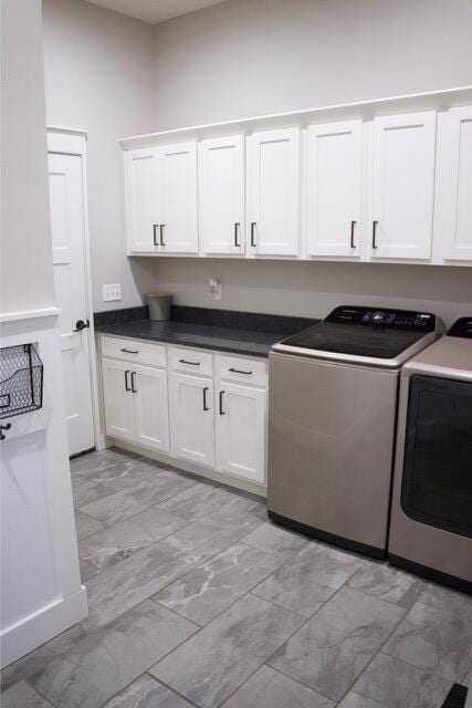 laundry area featuring cabinet space, washer and dryer, and marble finish floor