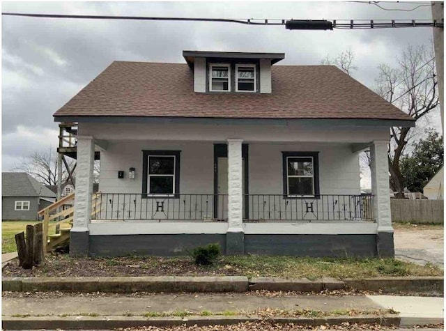 bungalow-style house with a porch and roof with shingles