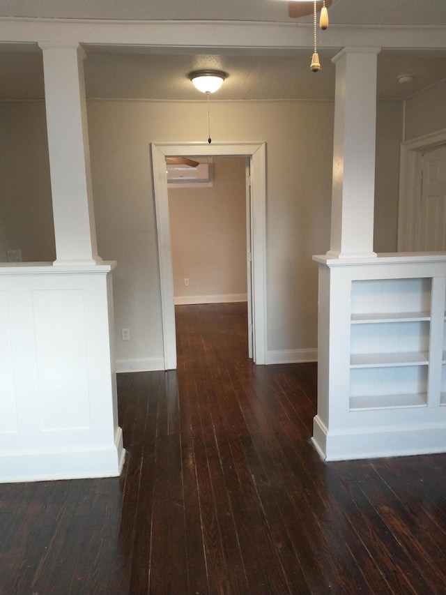 hall featuring built in features, an AC wall unit, baseboards, and hardwood / wood-style flooring