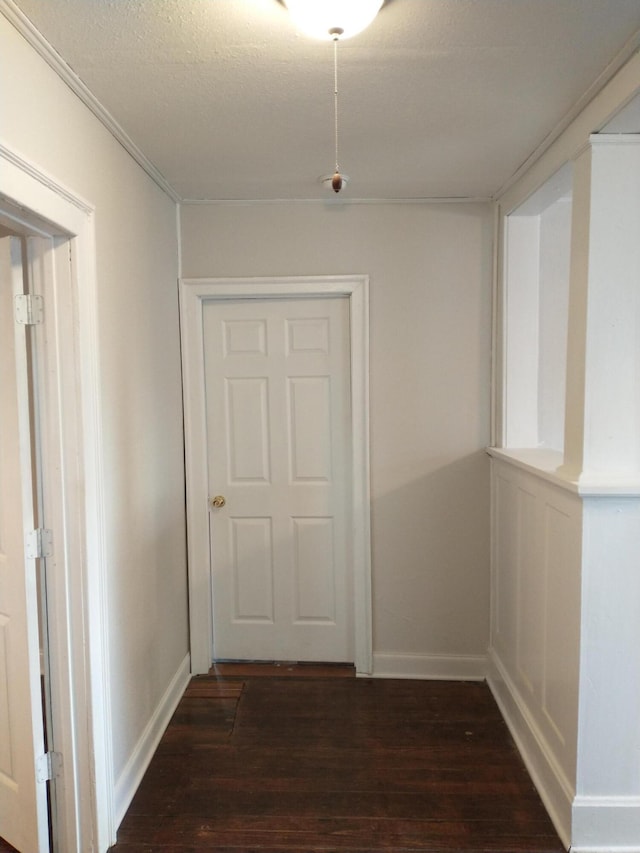 hallway featuring dark wood-type flooring, baseboards, and a textured ceiling