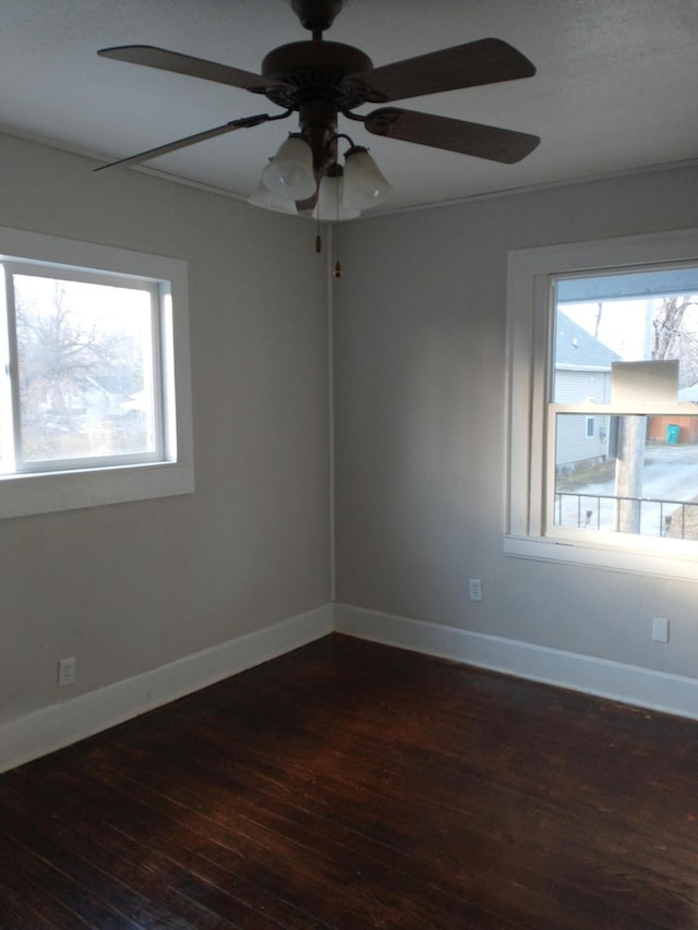 empty room with hardwood / wood-style flooring, a healthy amount of sunlight, and baseboards