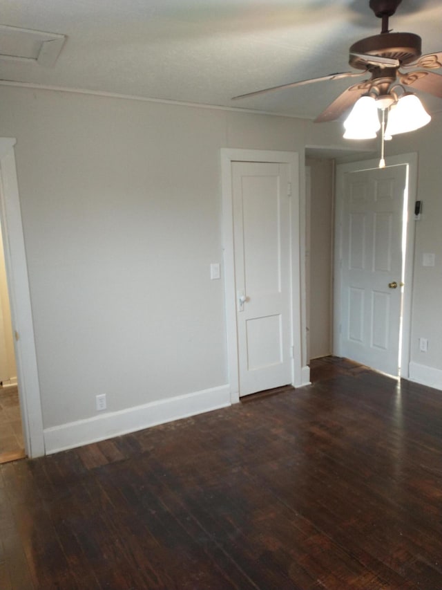 empty room featuring wood finished floors, a ceiling fan, and baseboards