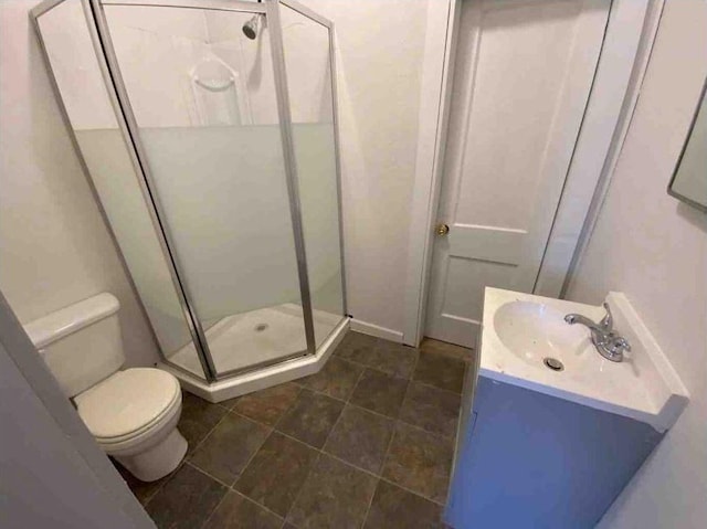 bathroom with vanity, toilet, and a shower stall