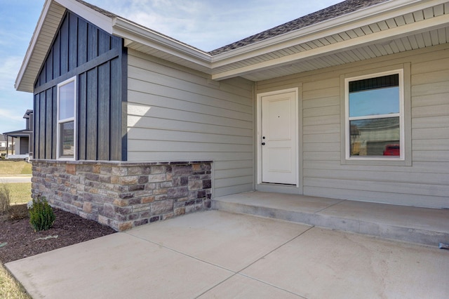 doorway to property featuring stone siding and board and batten siding