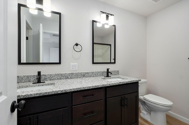 full bathroom featuring a sink, toilet, wood finished floors, and double vanity