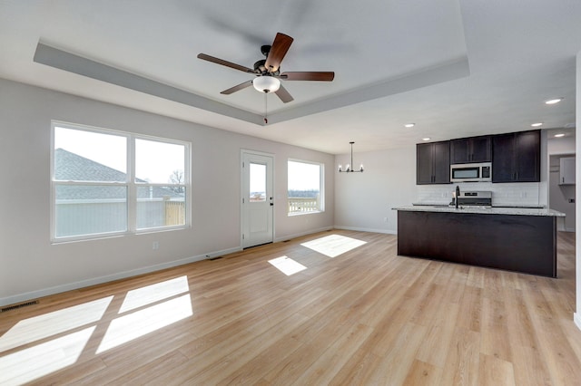 kitchen with visible vents, light countertops, a tray ceiling, appliances with stainless steel finishes, and light wood-style floors