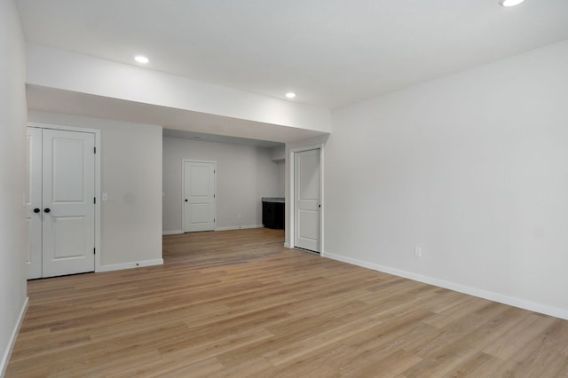 unfurnished room featuring light wood finished floors, recessed lighting, and baseboards