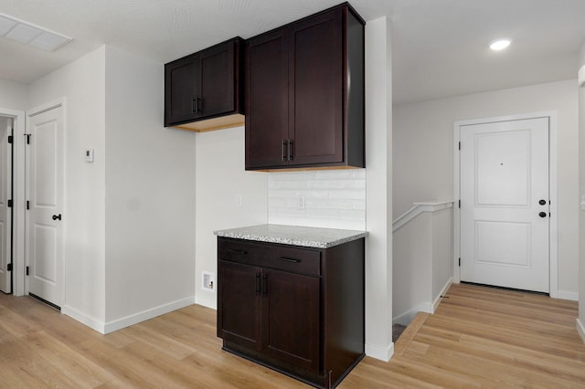 kitchen with dark brown cabinetry, visible vents, and light wood-type flooring