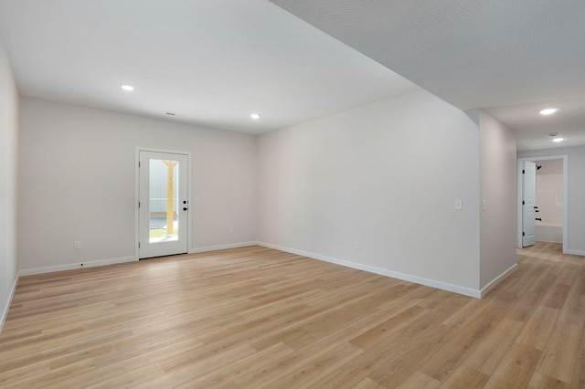 empty room featuring recessed lighting, baseboards, and light wood finished floors