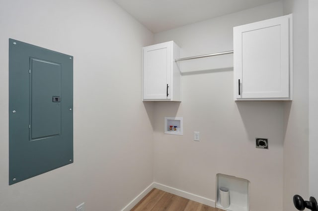 washroom with washer hookup, electric panel, light wood-style flooring, cabinet space, and electric dryer hookup